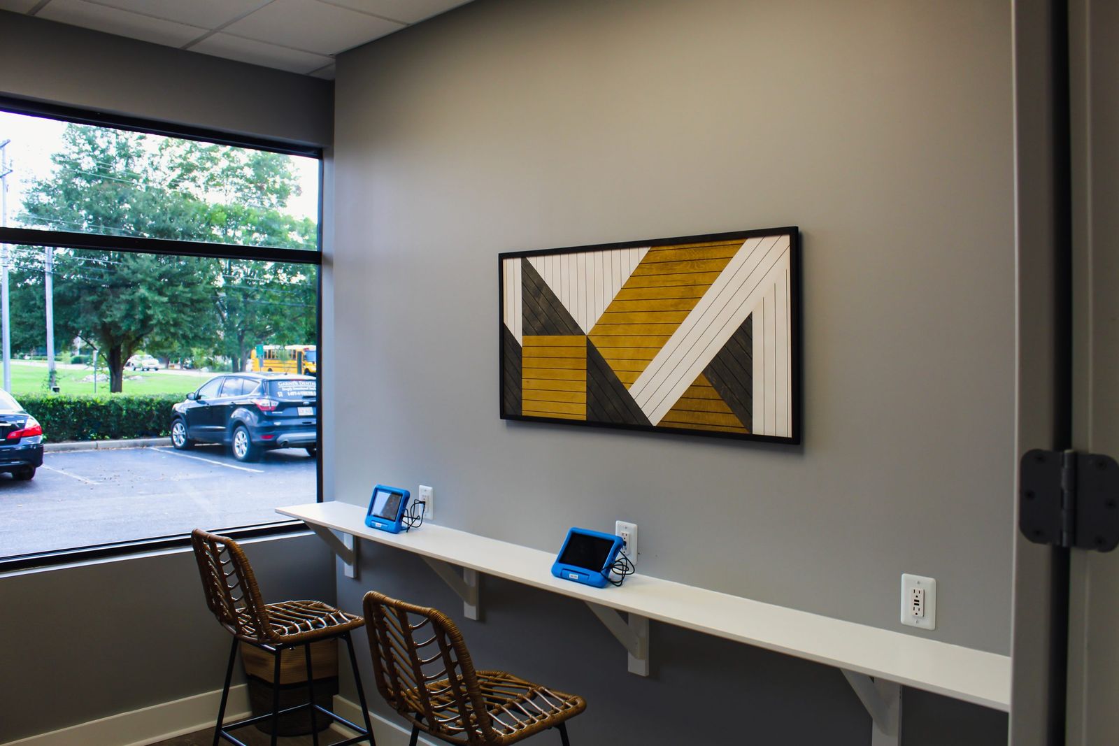 Check-in counter with tablets and stools by the front window