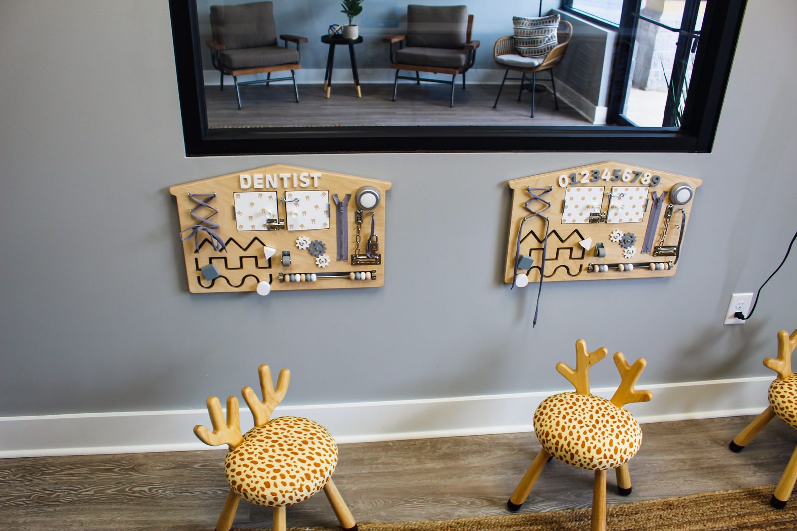 Play boards and small giraffe stools in the kids' corner of the waiting room